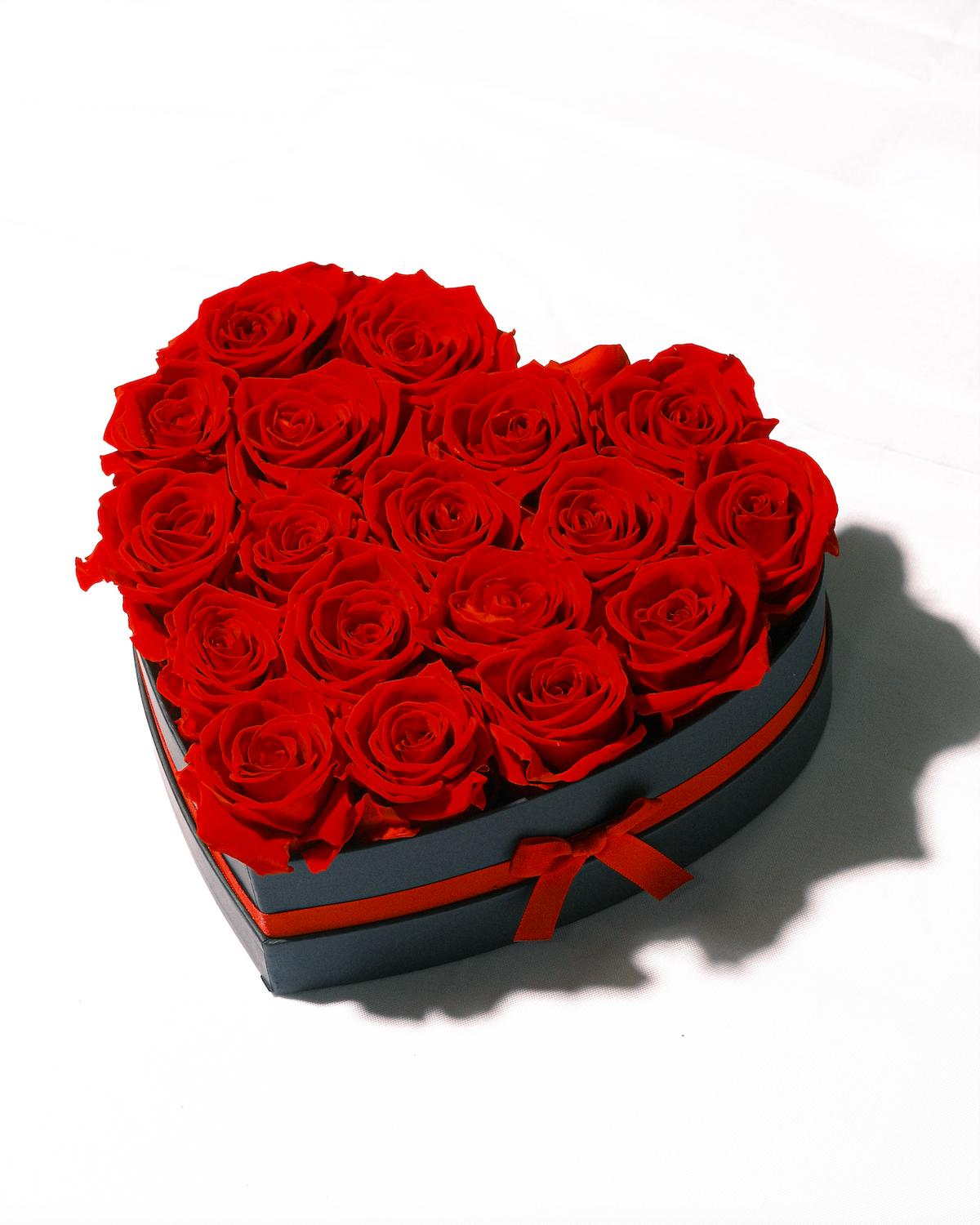 Eighteen red preserved roses in a heart-shaped box